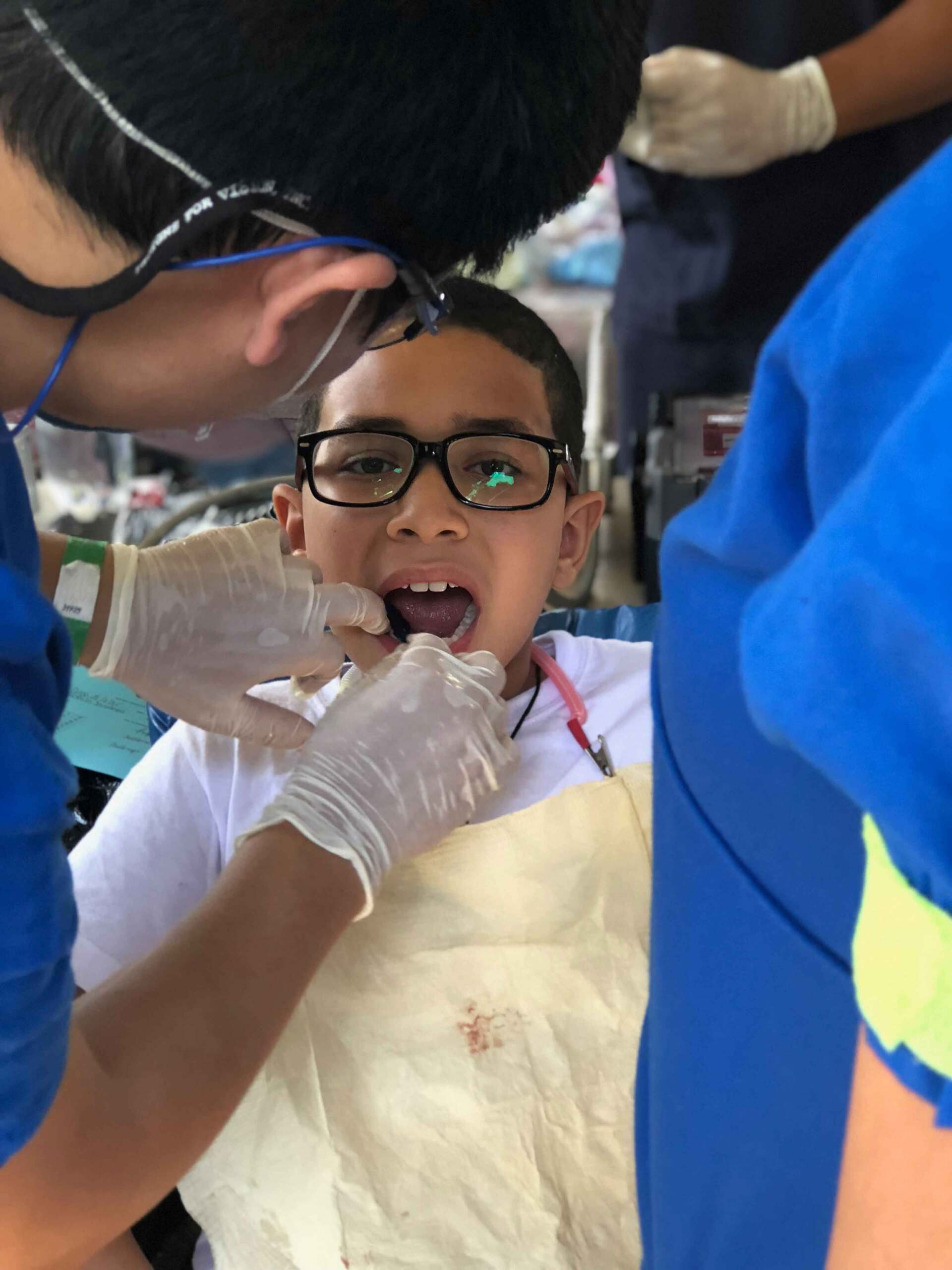 A young boy is getting his teeth examined by a dentist