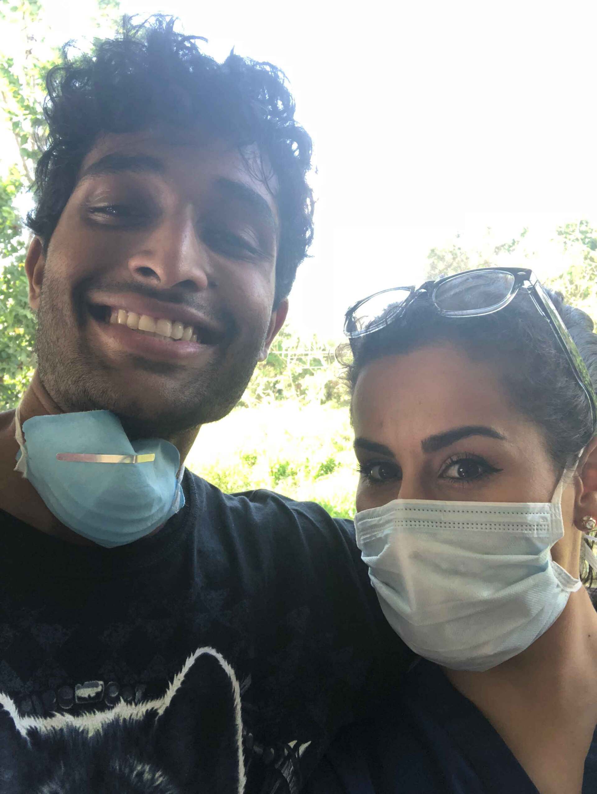 A man and a woman wearing face masks are posing for a picture.