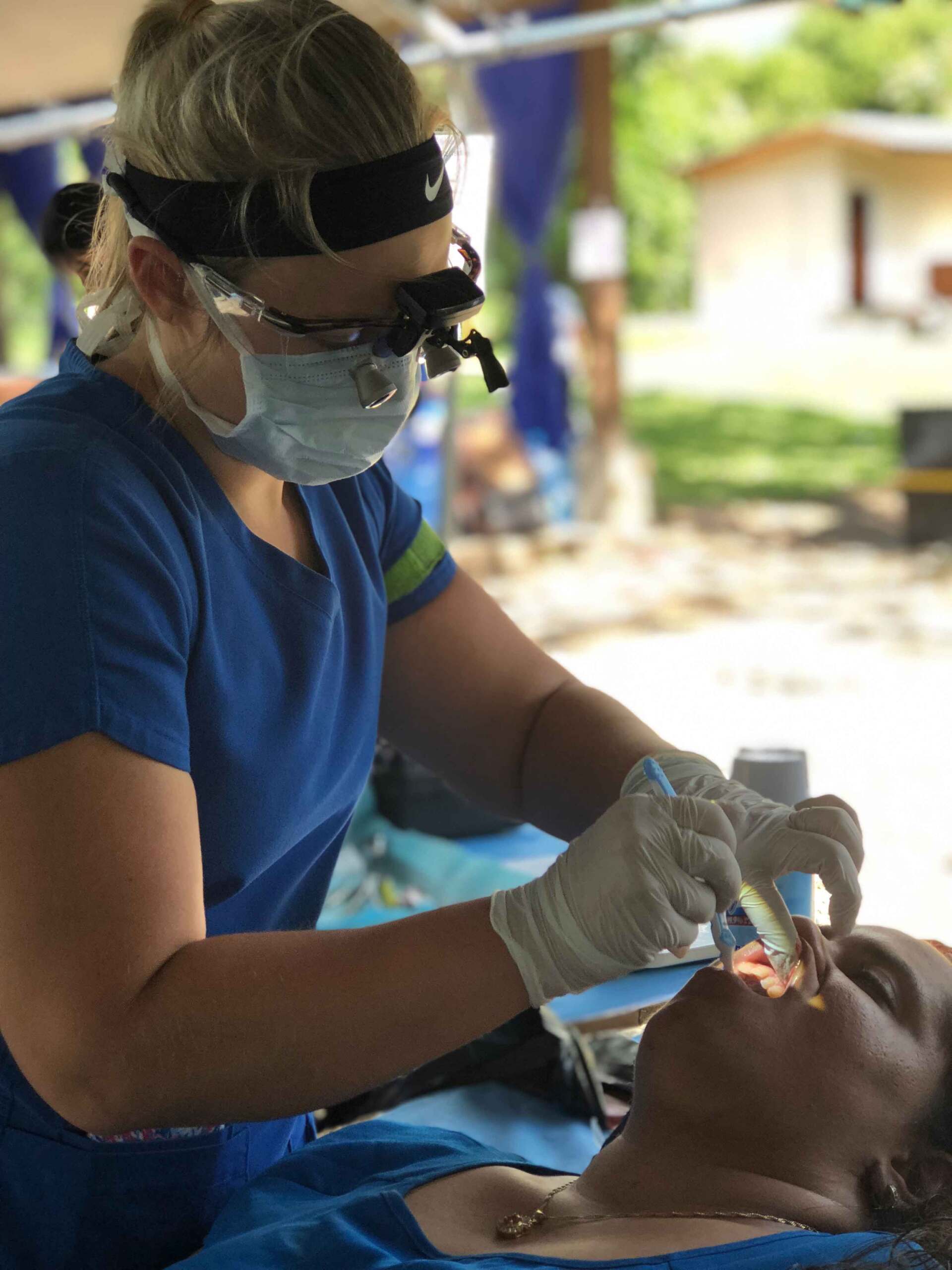 A woman is getting her teeth examined by a dentist