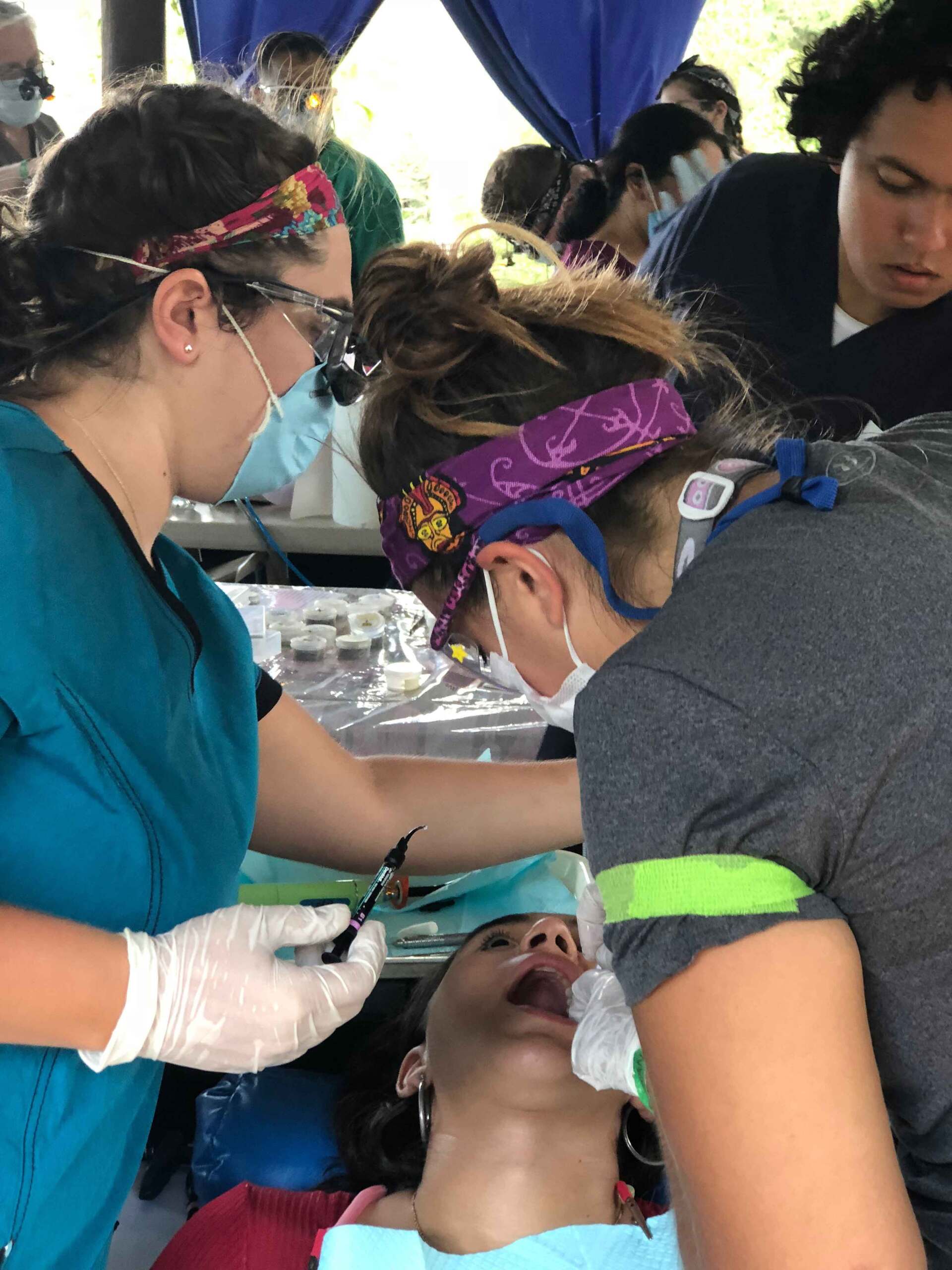 Two female dentists are working on a child 's teeth