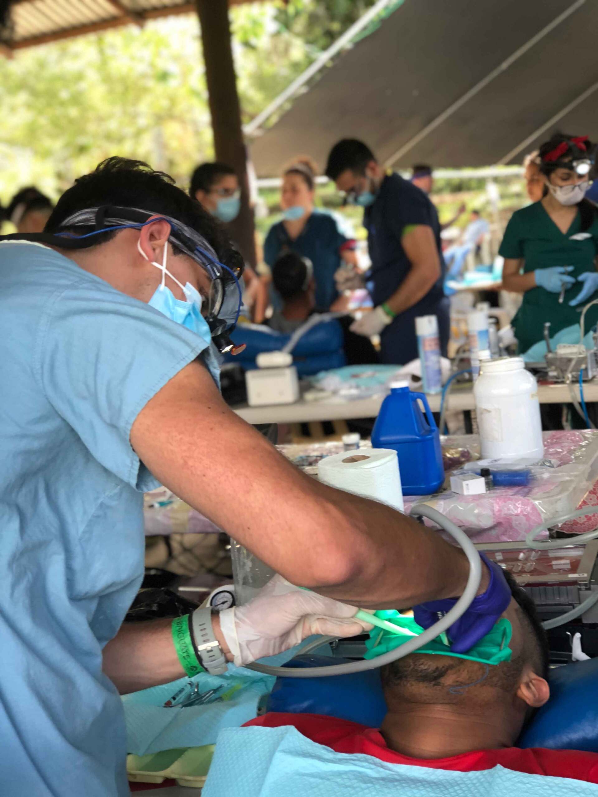 A man in a blue shirt is working on a child 's teeth