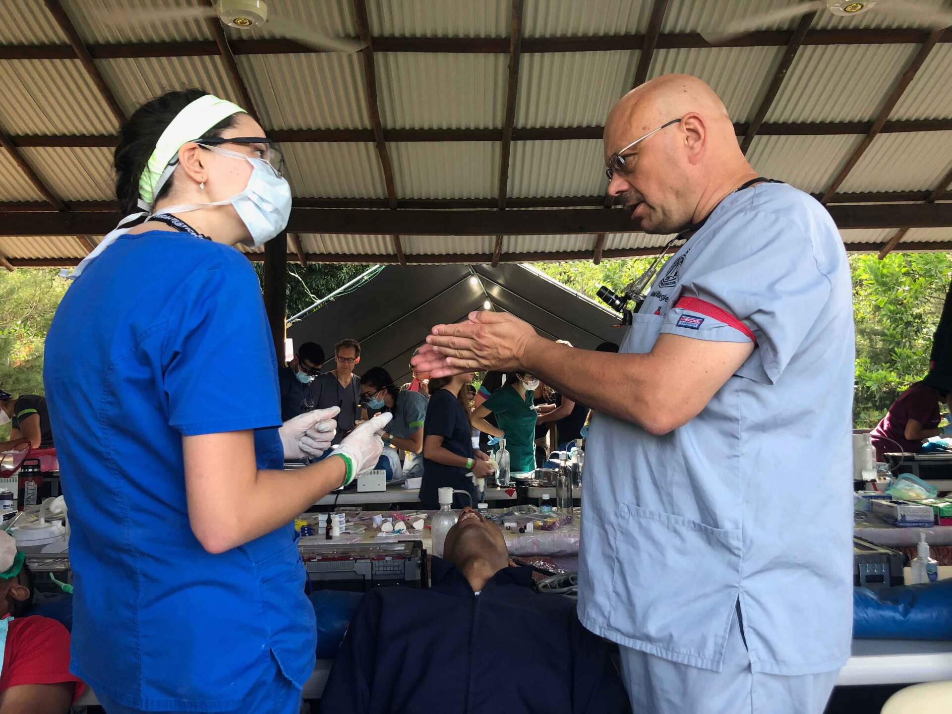 A man and a woman in scrubs are talking to each other