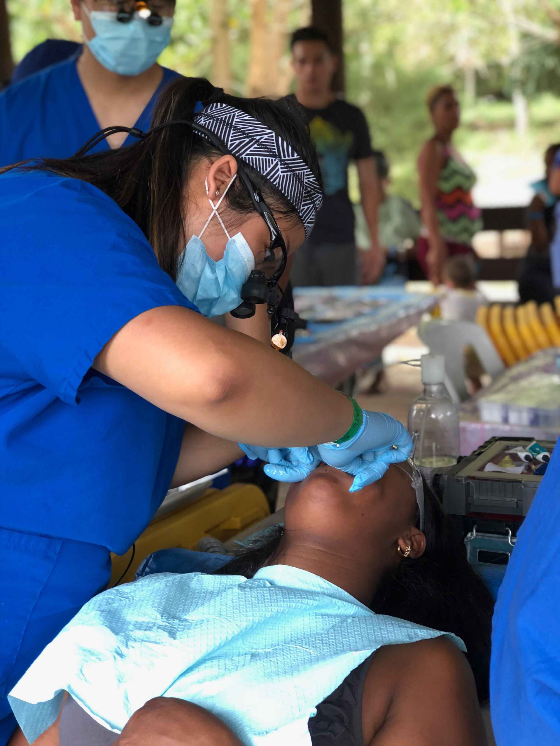 A woman is getting her teeth examined by a dentist.