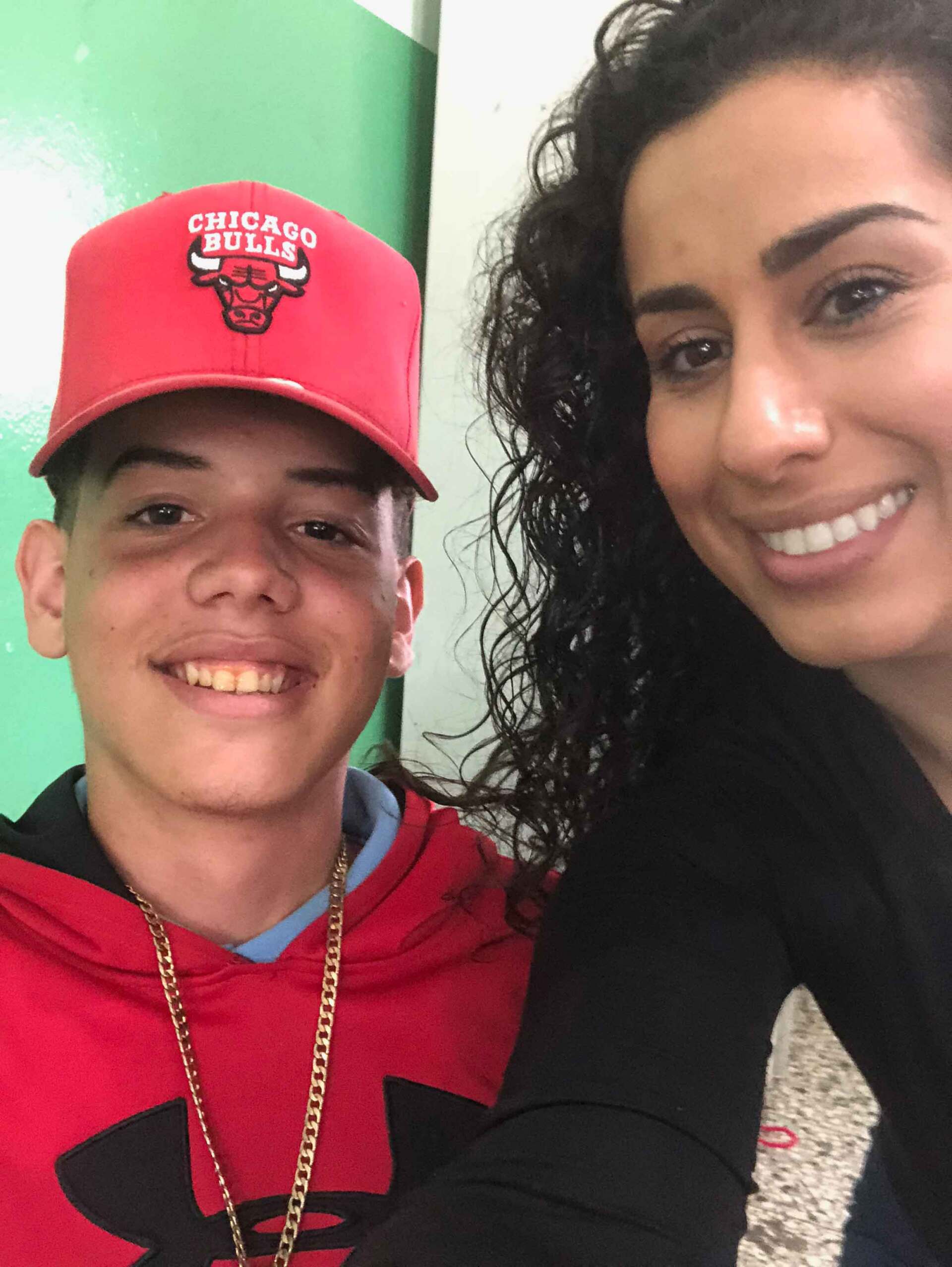 A man wearing a chicago bulls hat smiles next to a woman