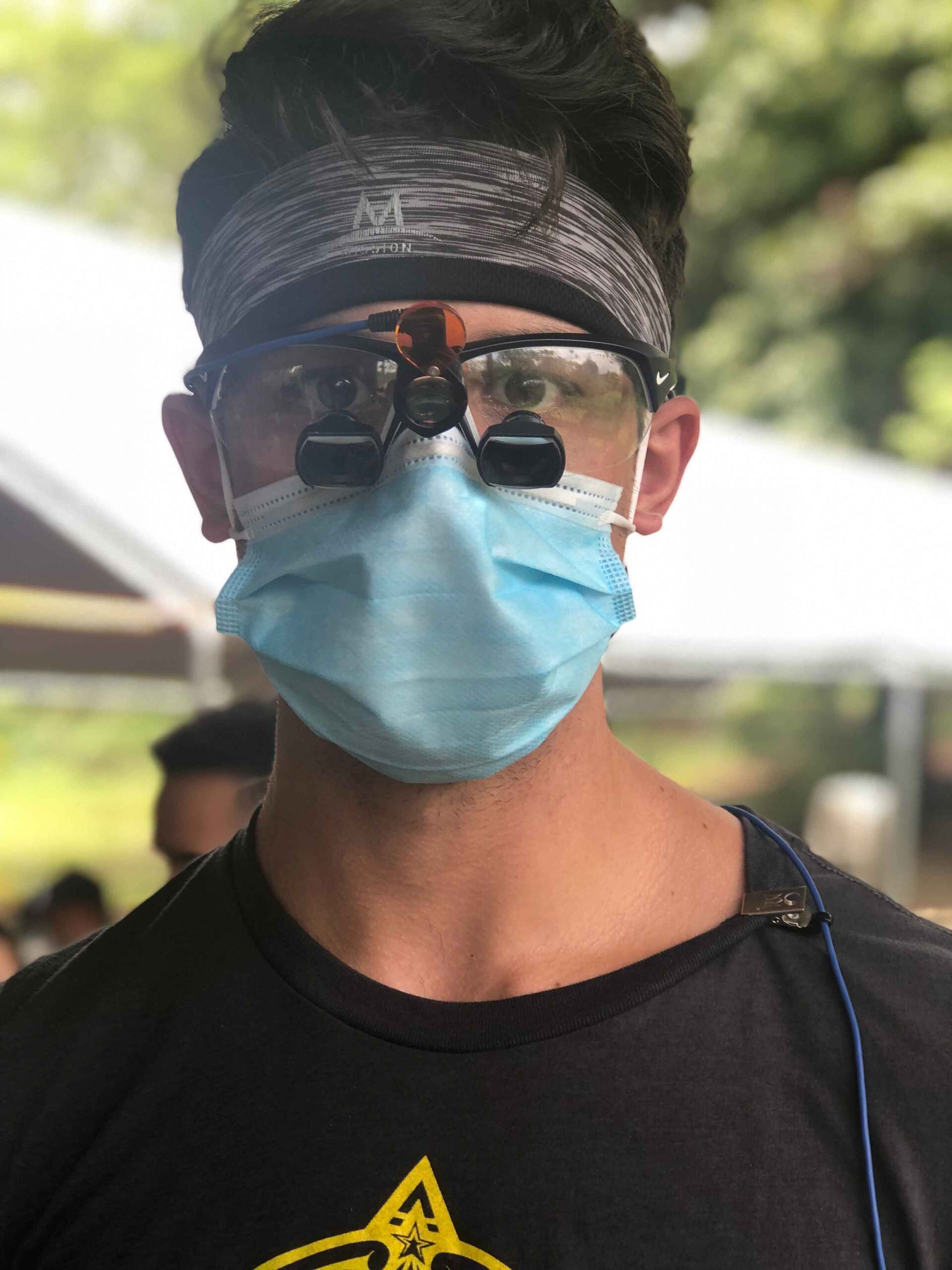A man wearing a face mask and magnifying glasses