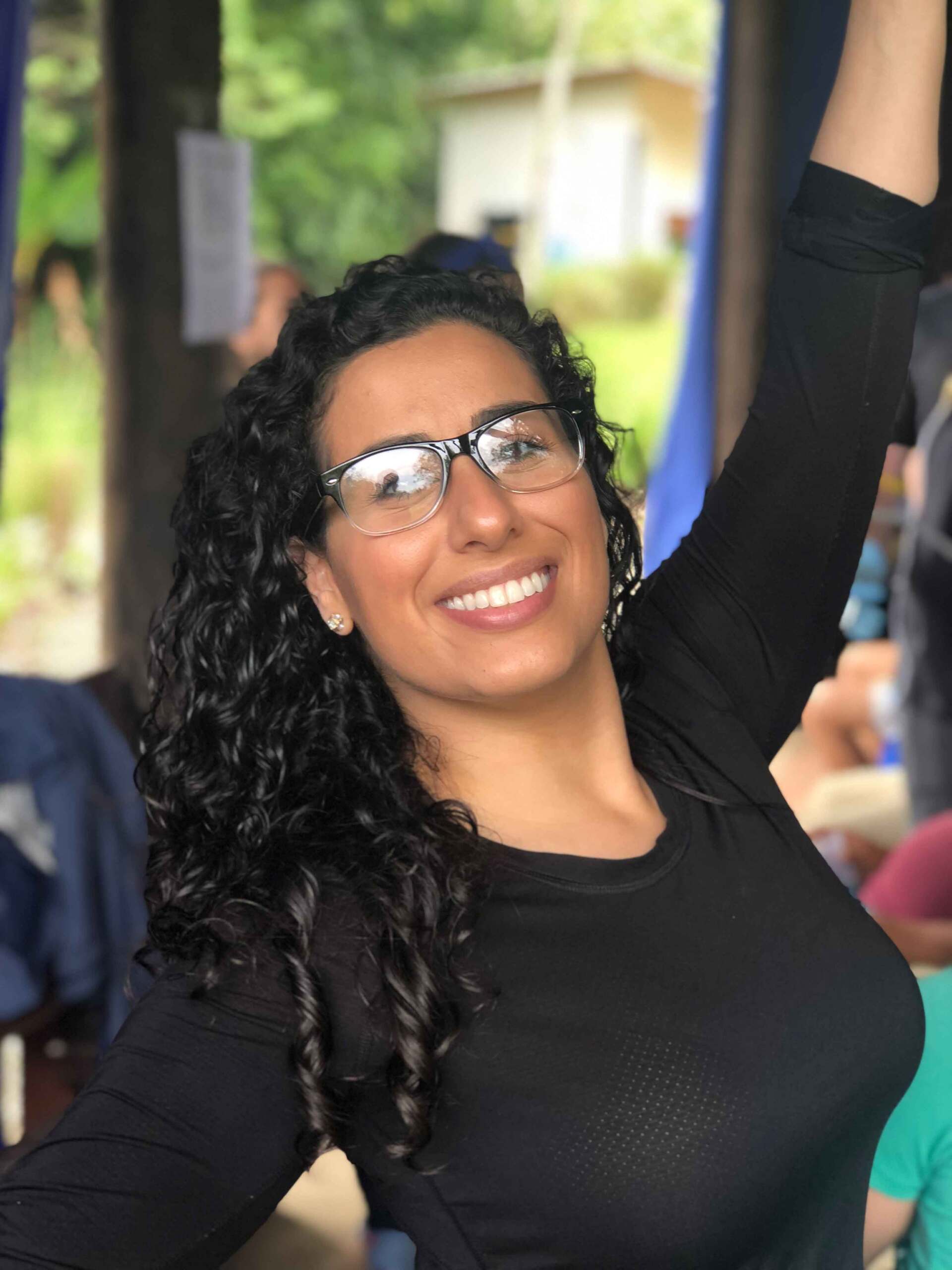 A woman wearing glasses and a black shirt is smiling