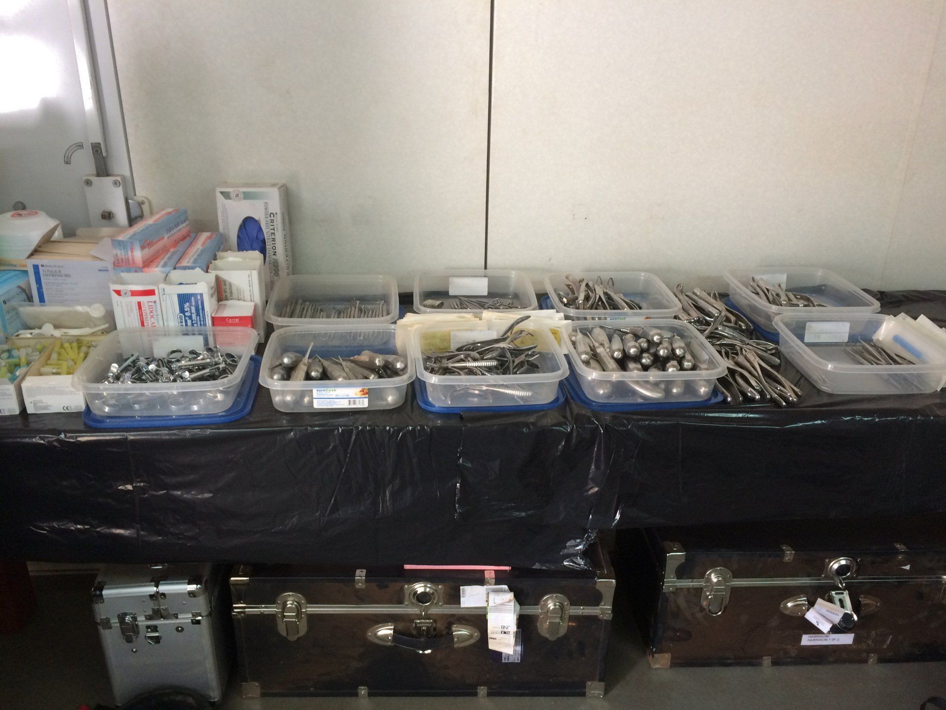 A table with a bunch of containers of tools on it