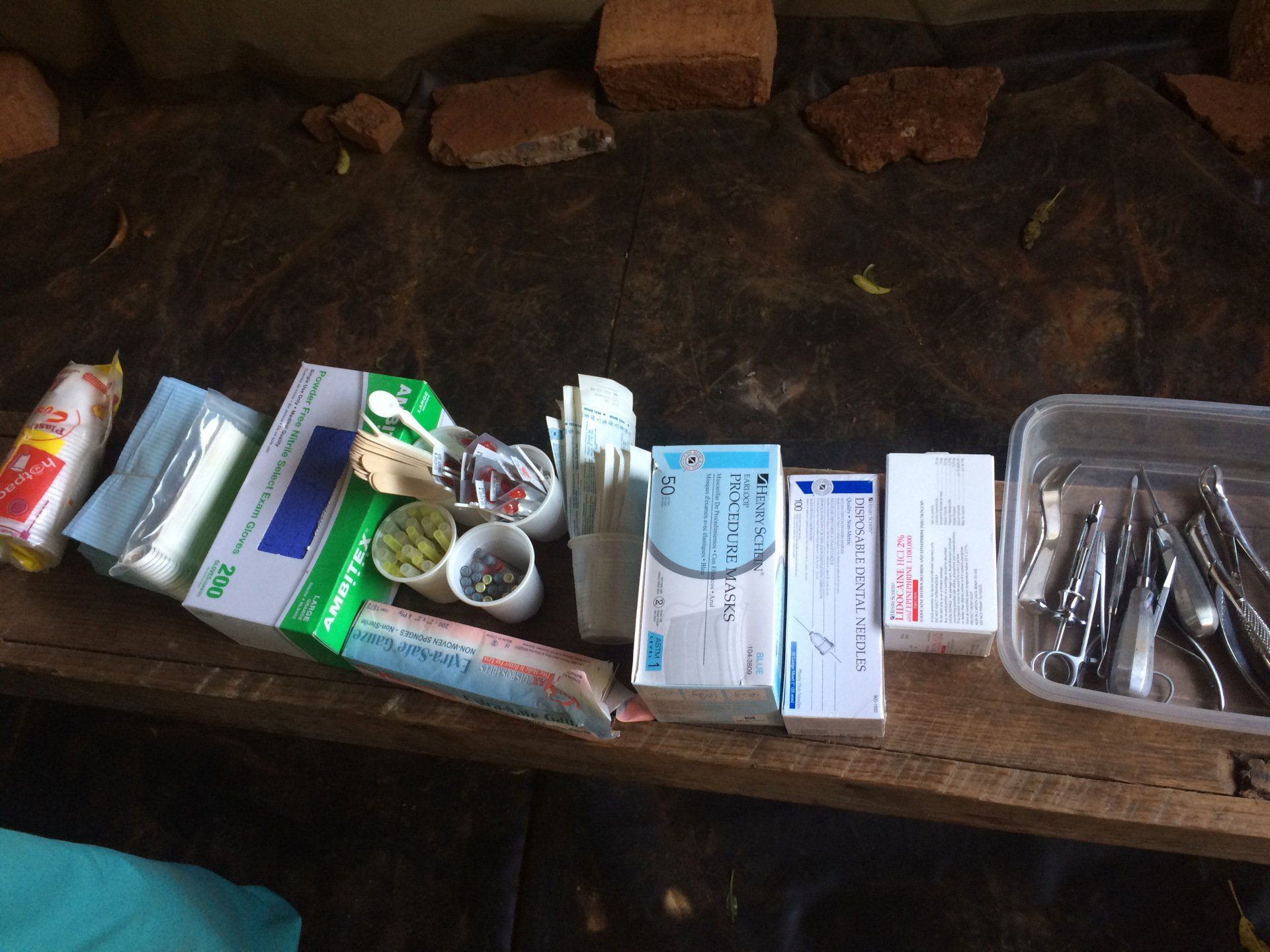 A wooden table topped with boxes of medicine and dental instruments.
