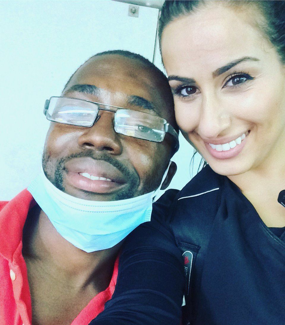 A man wearing glasses and a mask poses with a woman