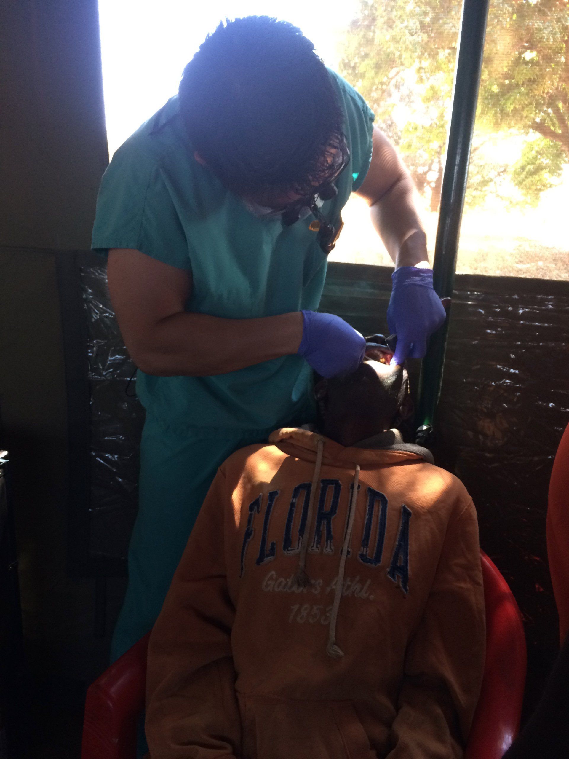 A person wearing a florida sweatshirt is being examined by a doctor