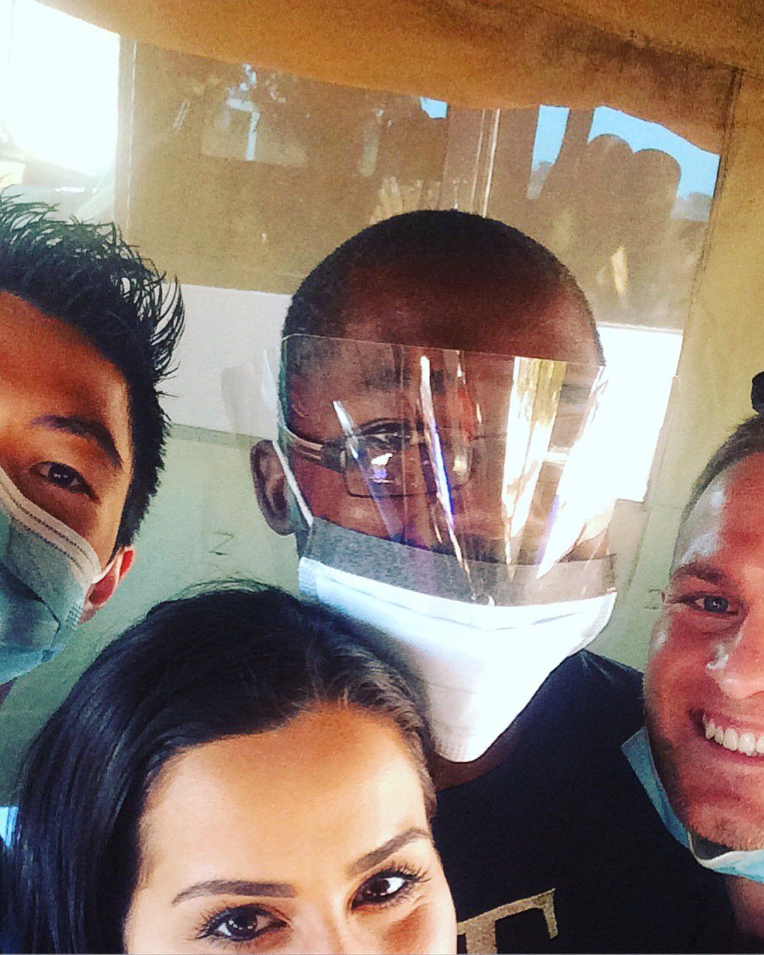 A group of people wearing masks and face shields