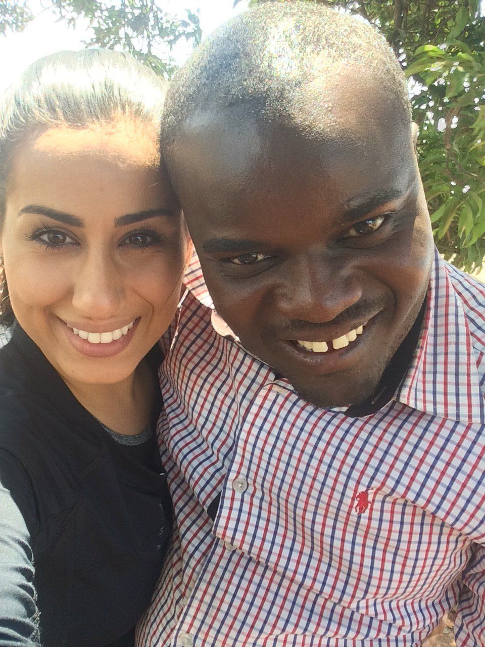 A man and a woman are posing for a picture and smiling for the camera.