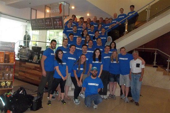 A group of people wearing blue shirts are posing for a picture
