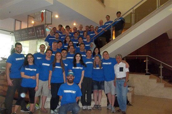 A large group of people wearing blue shirts are posing for a picture