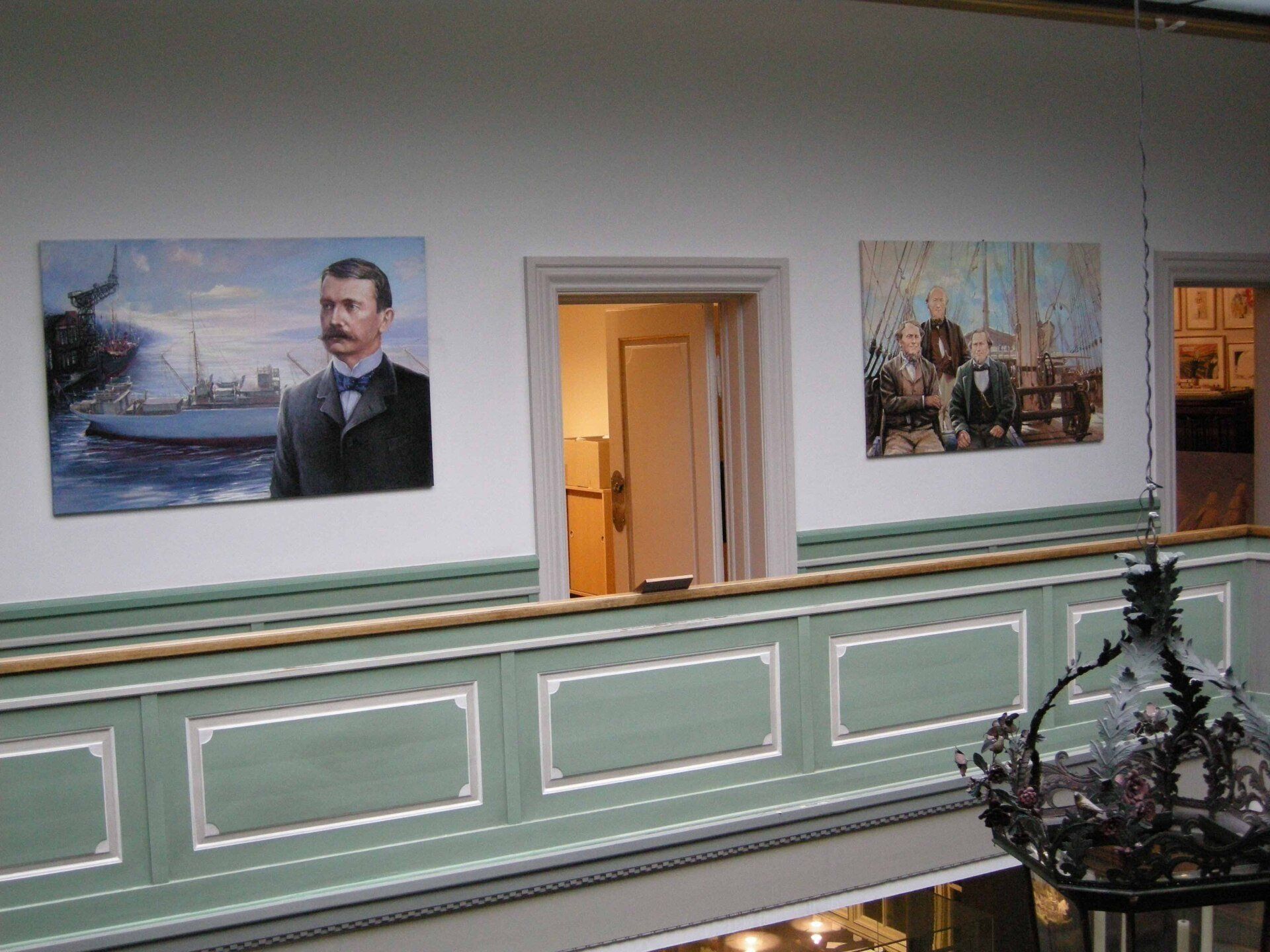 Office interior showing portraits by Mariusz Kaldowski on the walls