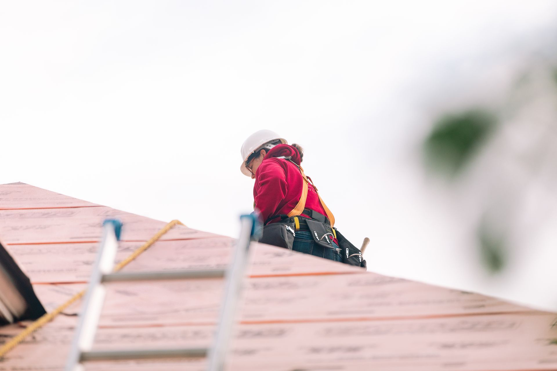 Professional residential roofing project featuring roofer installing roof underlayment. Professional residential roofing project featuring roofer installing roof underlayment.