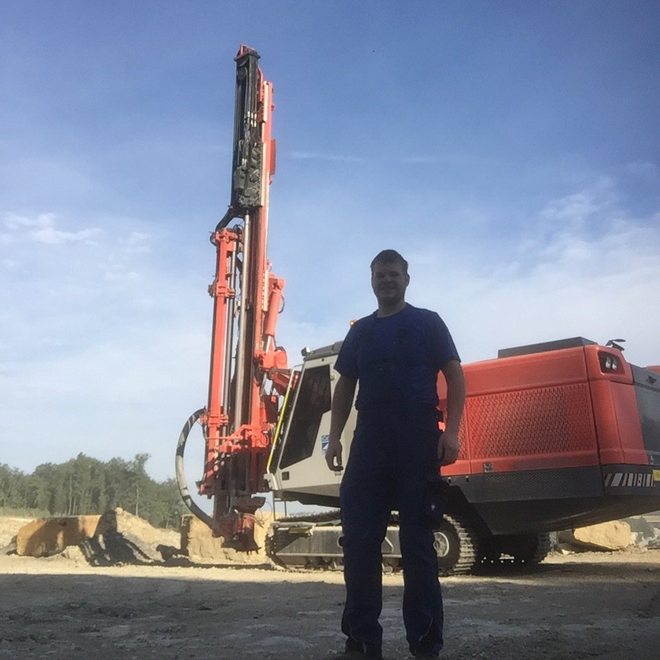 Simeon Weißert auf einer Baustelle vor Baumaschinen