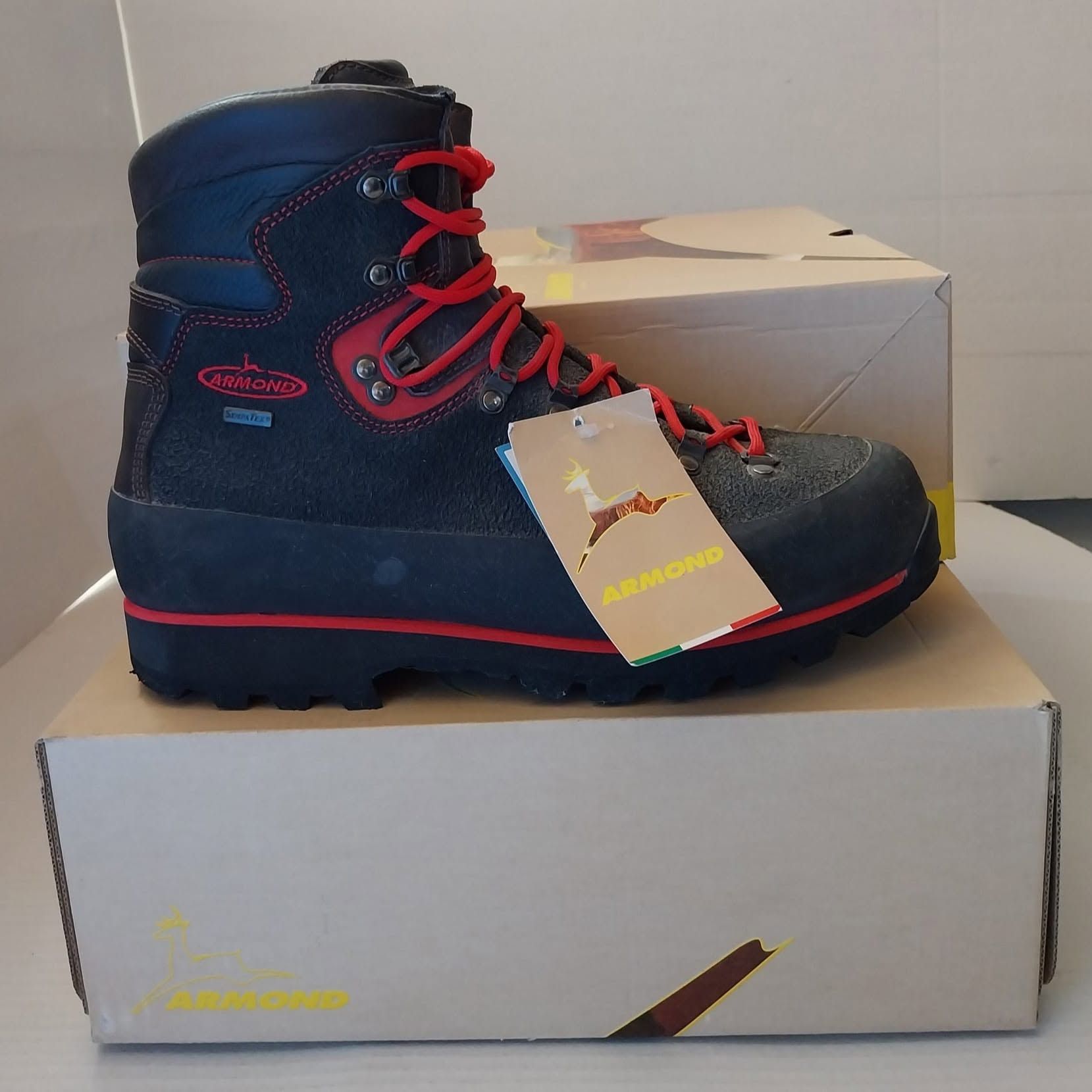 Scarponcino da trekking nero e rosso su una scatola da scarpe con un cartellino appeso