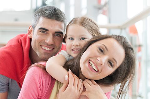 A family is posing for a picture together and smiling.