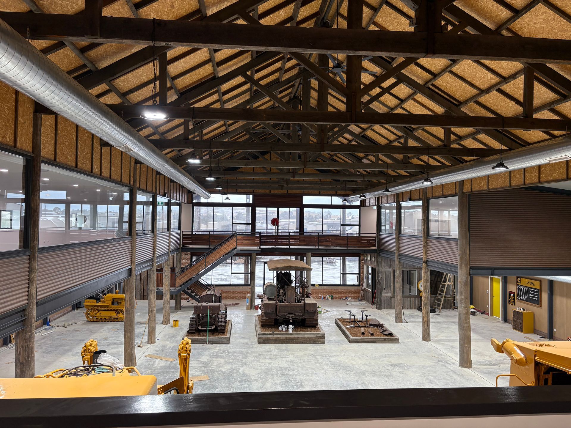 Interior view of a museum with heavy machinery exhibits. Wooden beams and large windows are visible — SJD Electrical Contracting in Lithgow, NSW