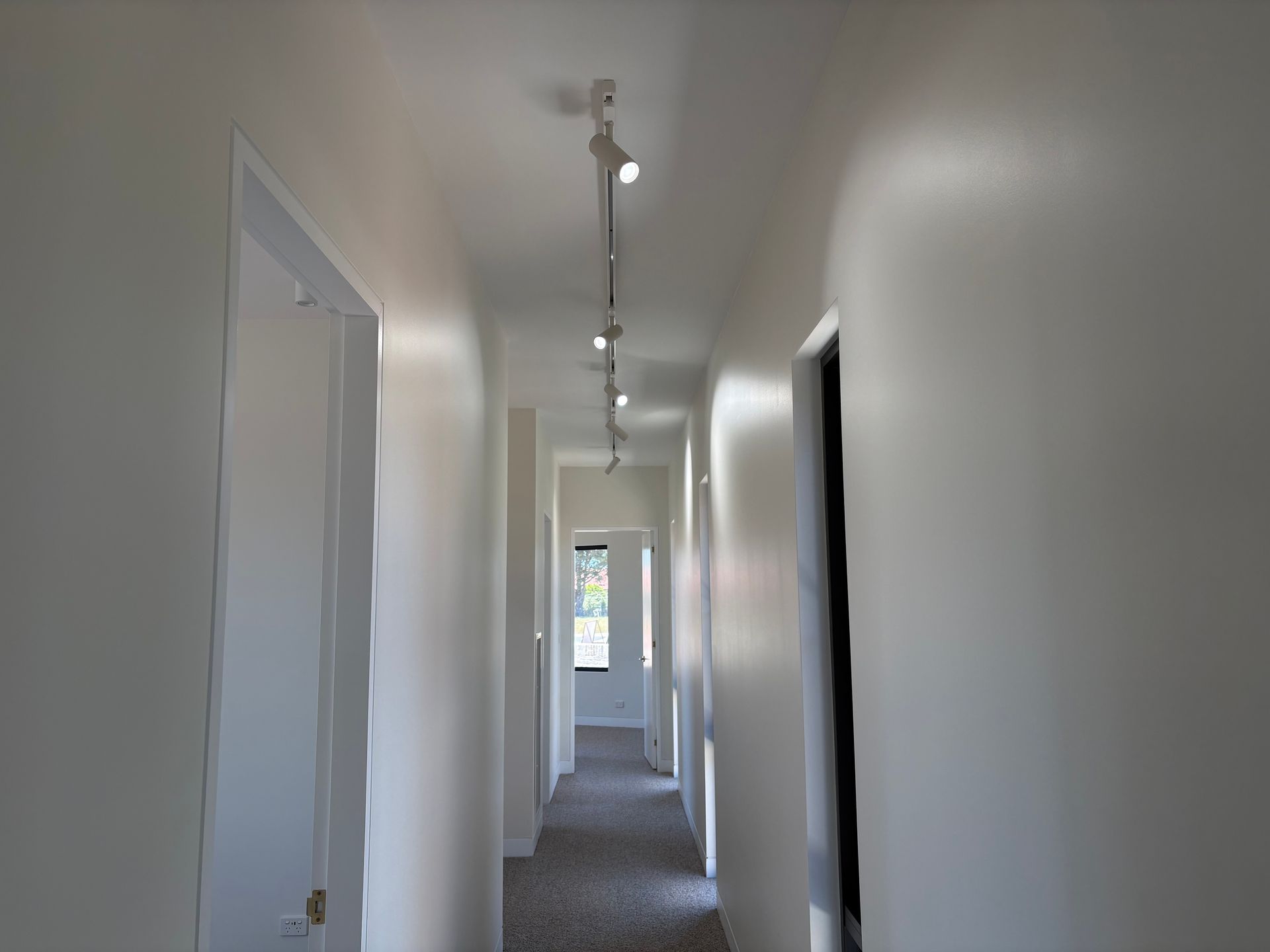 Hallway with white walls, track lighting, and doorways — SJD Electrical Contracting in Cowra, NSW