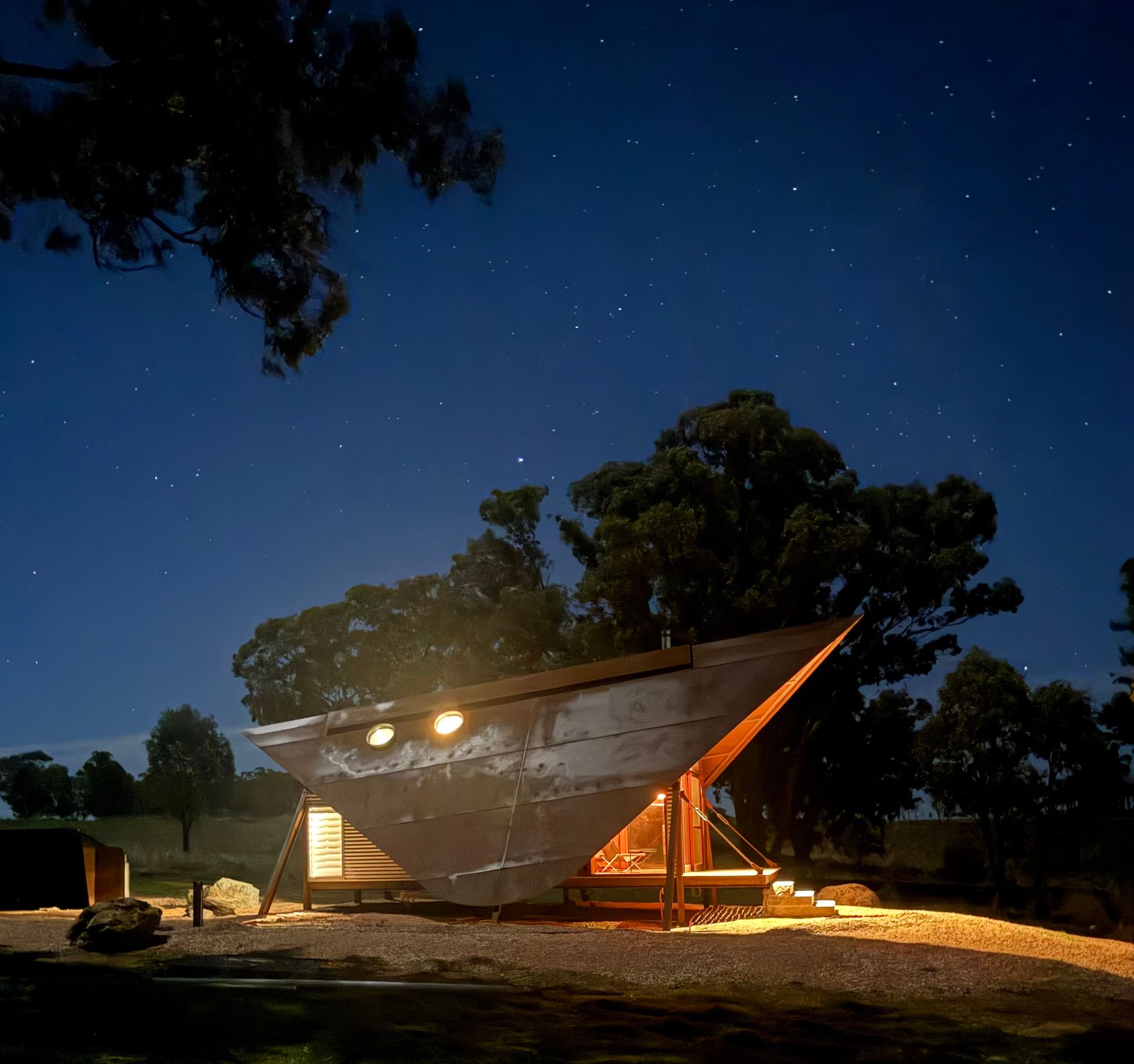 Boat-shaped cabin illuminated at night under a starry sky — SJD Electrical Contracting in Lithgow, NSW