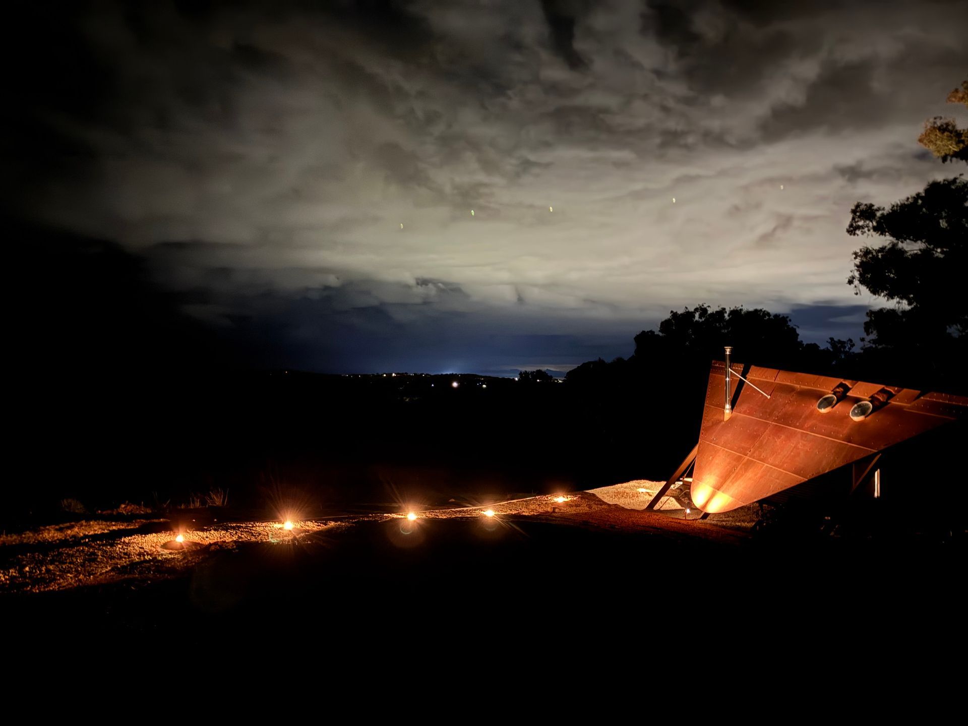 Night scene: Glowing lights in a row lead to a slanted, illuminated structure — SJD Electrical Contracting in Cowra, NSW