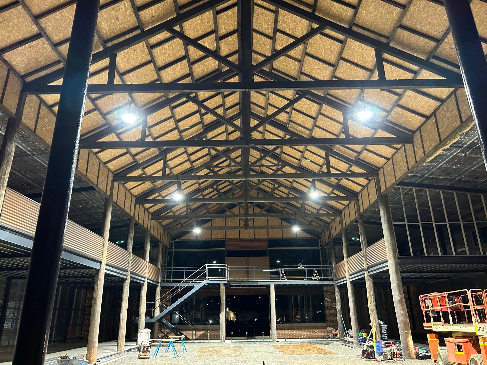 Interior view of a large building with a high, thatched roof. Wooden beams and supports — SJD Electrical Contracting in Bathurst, NSW