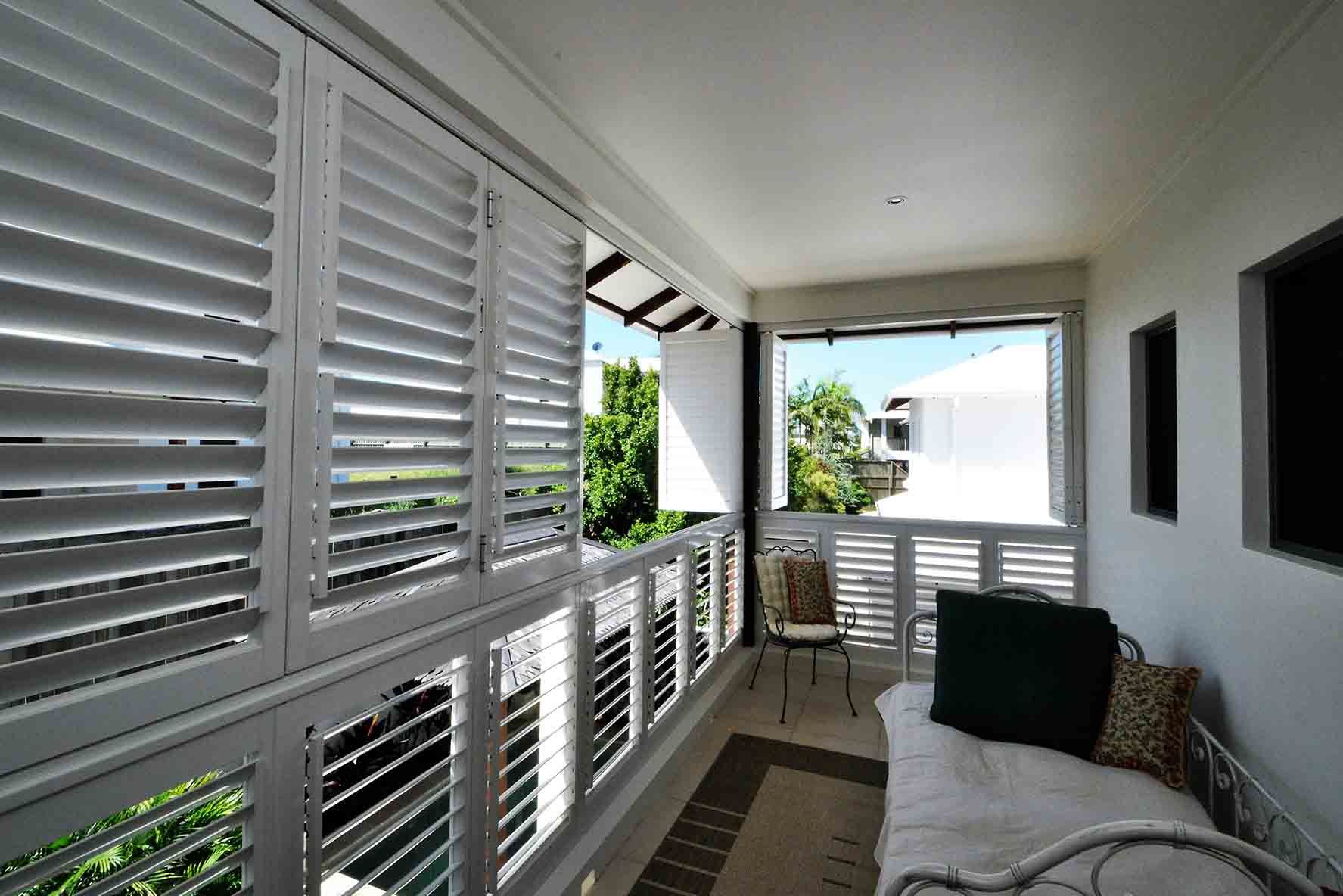 A Balcony With White Shutters And A Bed — Balcony Shutters Australia In Moffat Beach, QLD