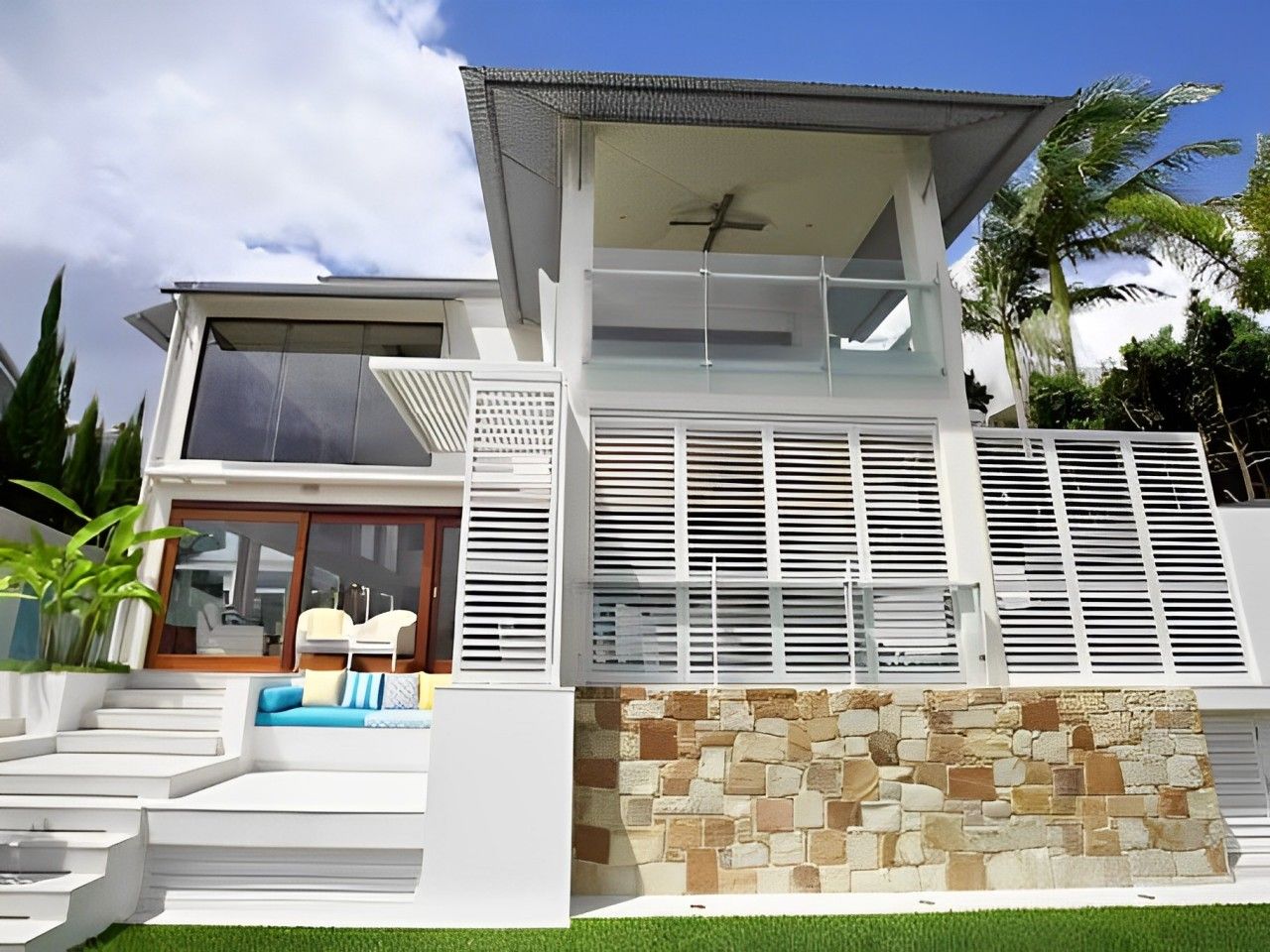 A White House With A Lot Of Windows And Stairs — Balcony Shutters Australia In Brisbane, QLD