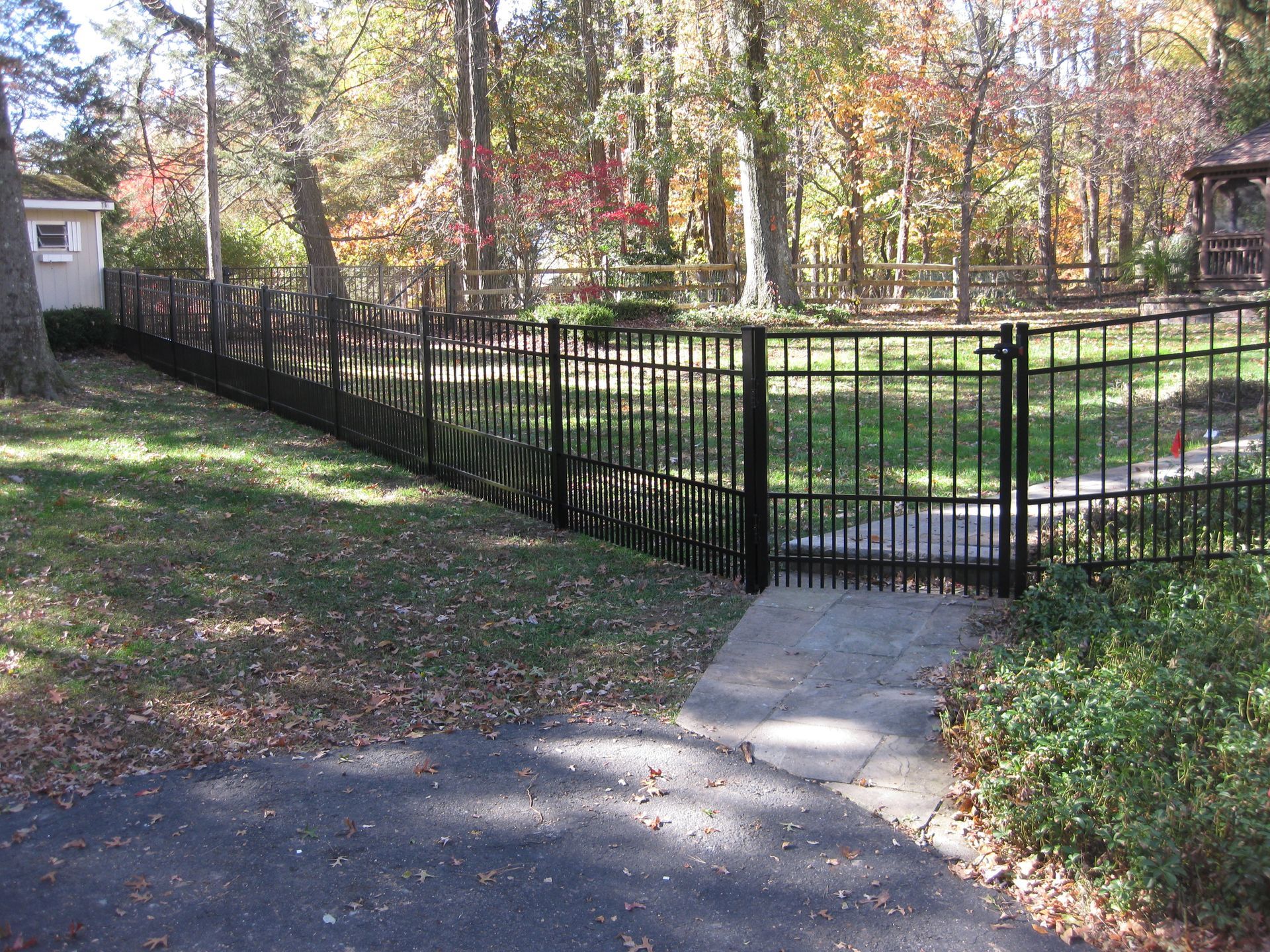 A black fence surrounds a lush green field