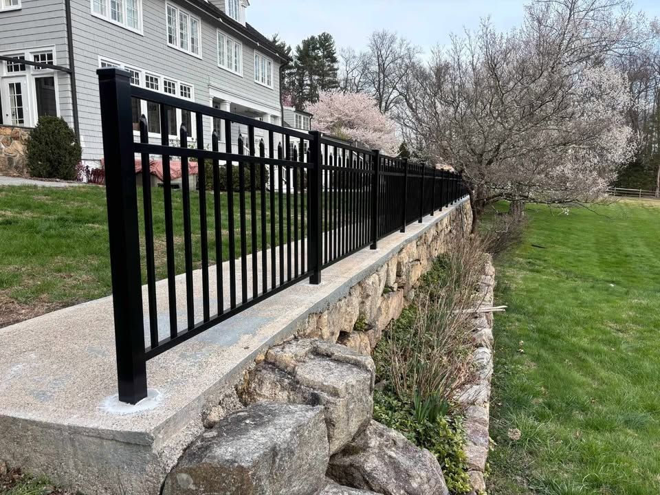 Black metal fence installed on a concrete base. Black metal fence installed on a concrete base.