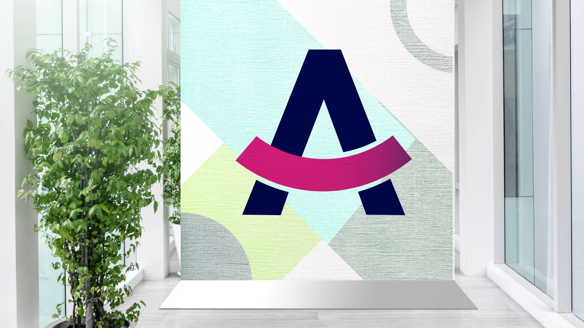 The letter A is on a wall next to a plant.