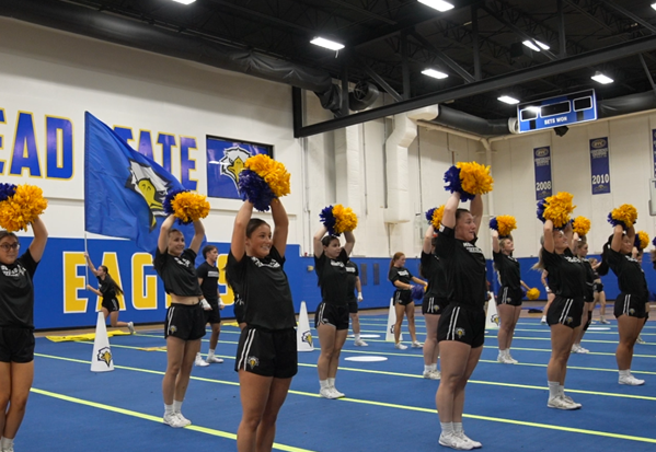 Action shot of athletes performing a dynamic cheer or dance routine at a skills camp