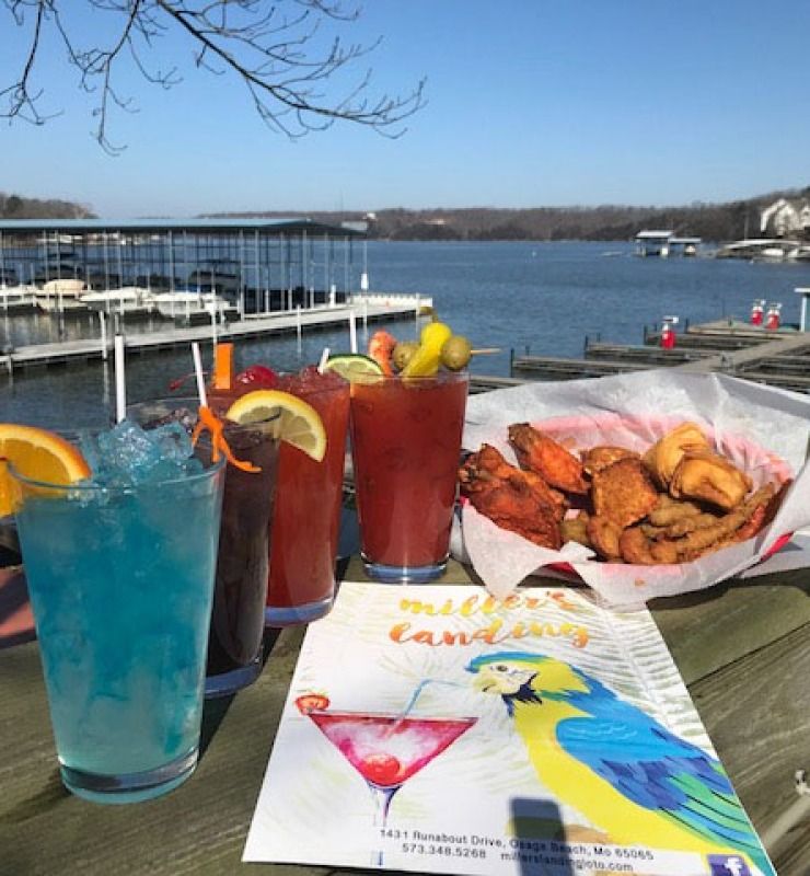 Colorful drinks and fried shrimp on a dockside table overlooking the water