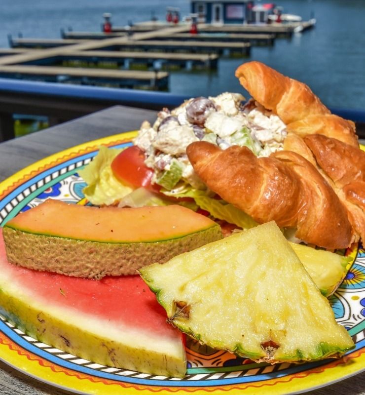 Colorful plated breakfast pastry with fruit by a marina on the water