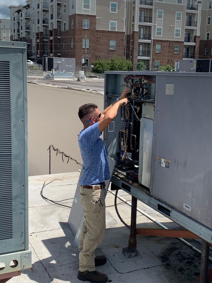 A technician repairing air conditioner - Tallahassee, FL - Todd King's Heating and Cooling A technician repairing air conditioner - Tallahassee, FL - Todd King's Heating and Cooling