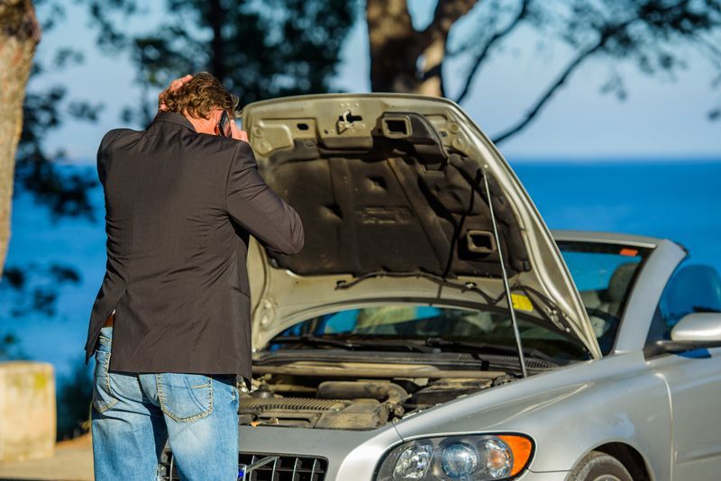 A Man Is Looking Under The Hood Of A Broken Down Car — APPS Mechanical Port Macquarie In Port Macquarie, NSW
