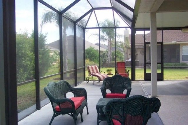 Furnished porch showcasing a modern screen enclosure, representing stylish outdoor living space. Furnished porch showcasing a modern screen enclosure, representing stylish outdoor living space.