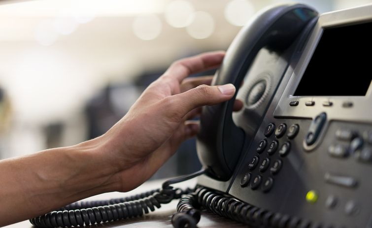 employee man hand touching handset of telephone