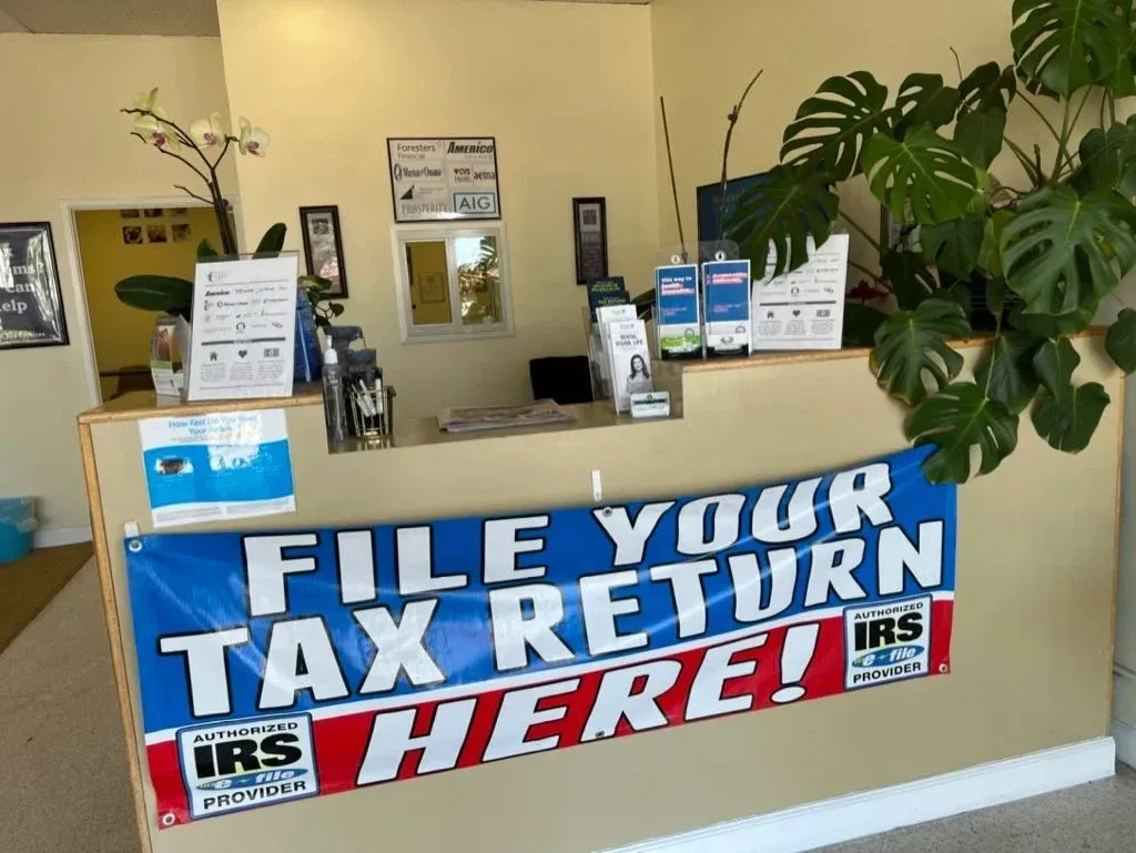 Tax office counter with banner reading “FILE YOUR TAX RETURN HERE!” and IRS signs