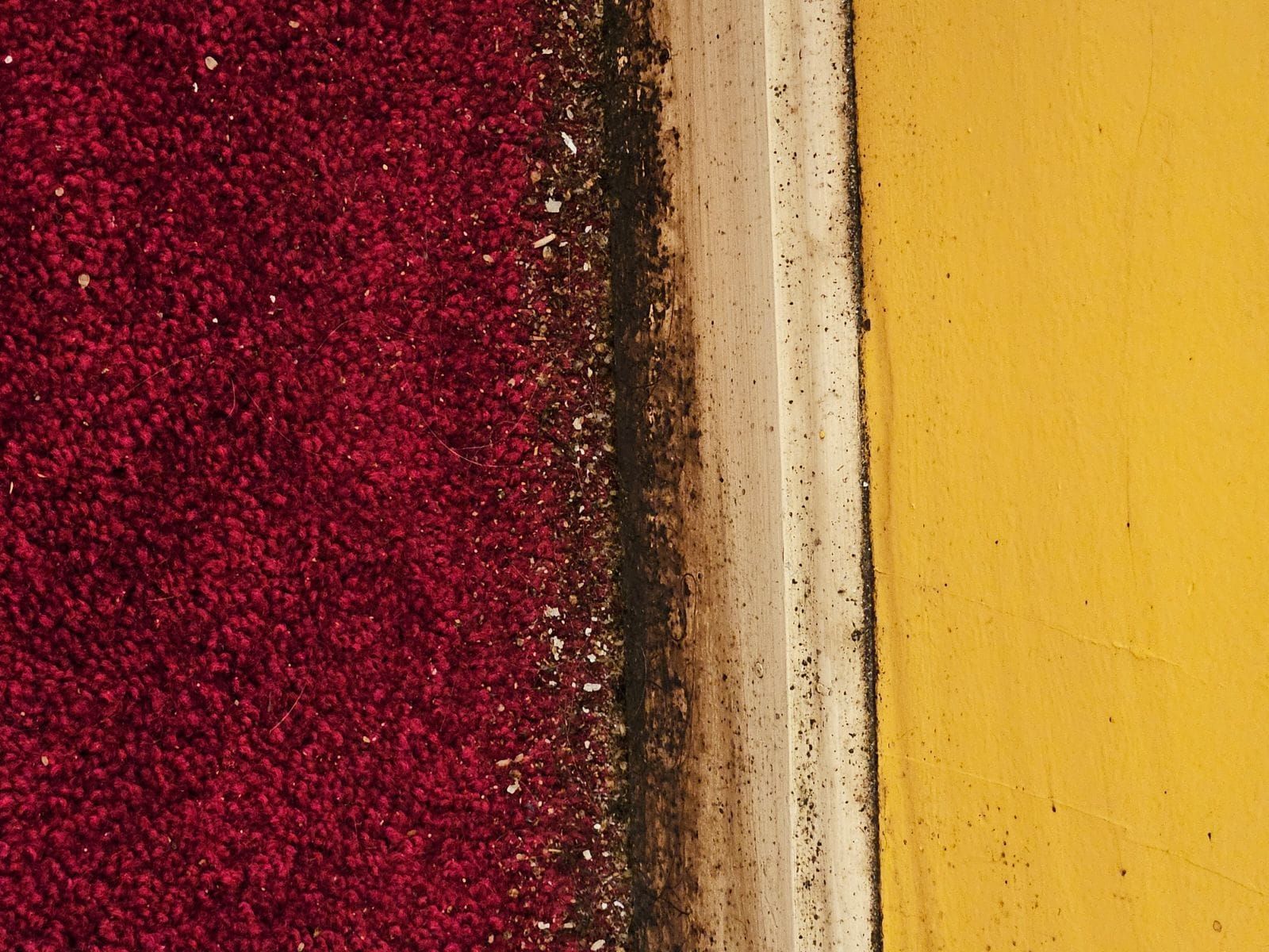 Red glittery texture beside a cream and yellow painted wall corner