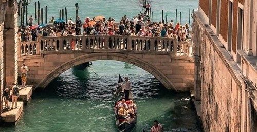Gondola under bridge in Venice canal