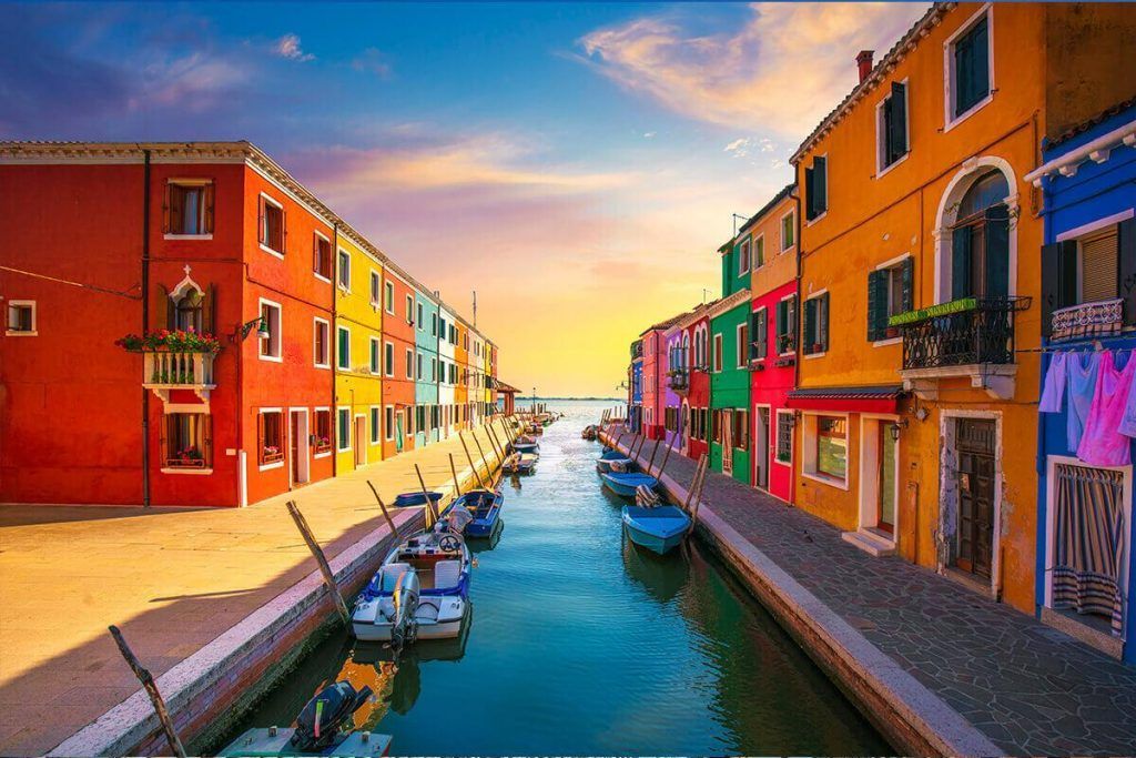 Colorful houses along a canal on the island of Burano at sunset.