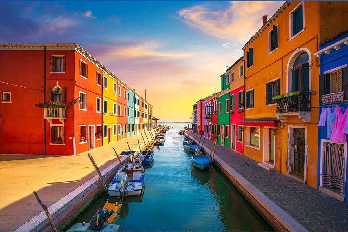 Picturesque view of the colorful houses and canal of Burano island at sunset.
