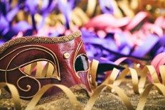 Red carnival mask with golden streamers