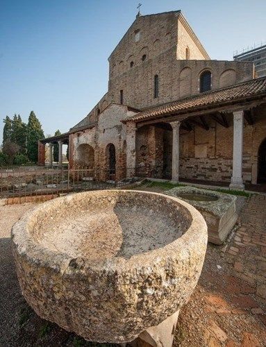 Ancient stone well and church in Torcello.