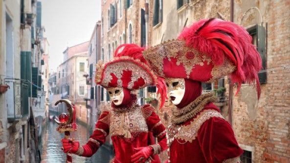 People in traditional red and gold Venetian Carnival costumes.