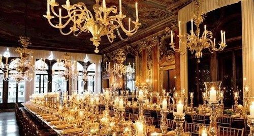 The opulent interior of Palazzo Pisani, illuminated by hundreds of glowing candles and magnificent crystal chandeliers