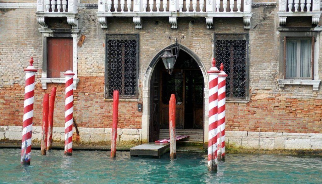 Entrance to a Venetian palace with red and white striped mooring poles